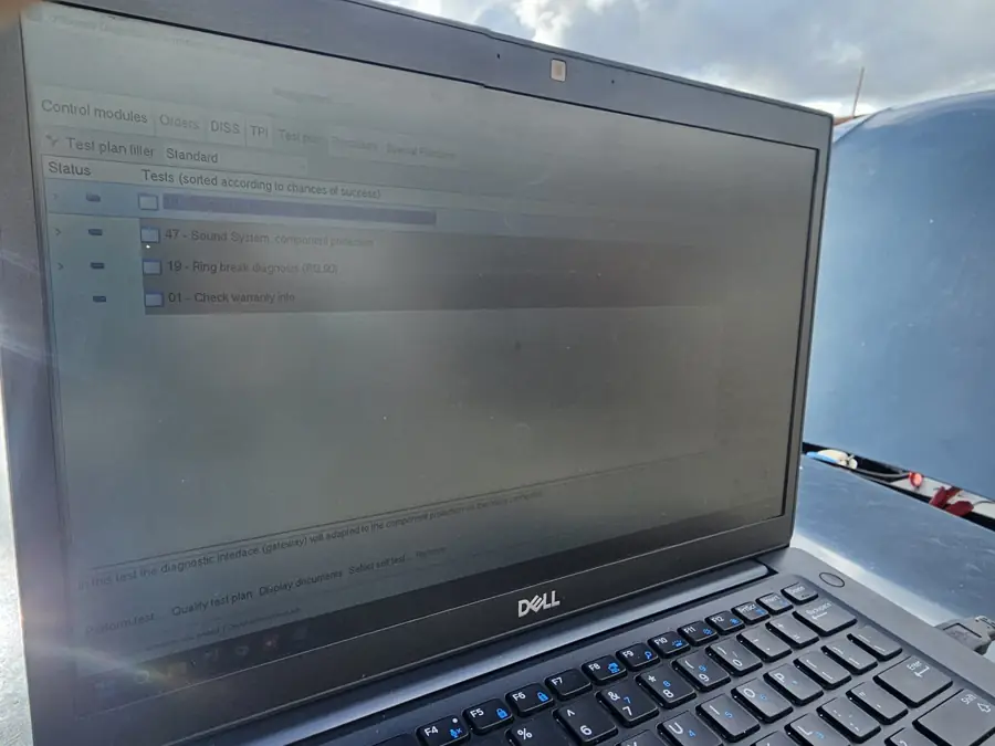 Laptop running manufacturer-level diagnostics on a European car